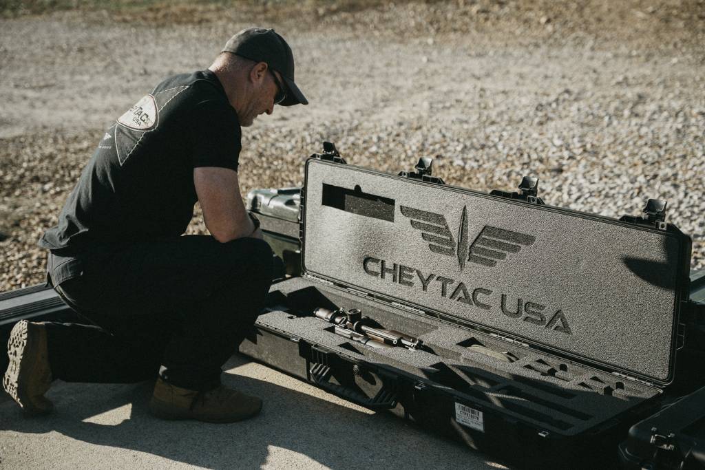 A man standing over a m200 rifle deployment kit