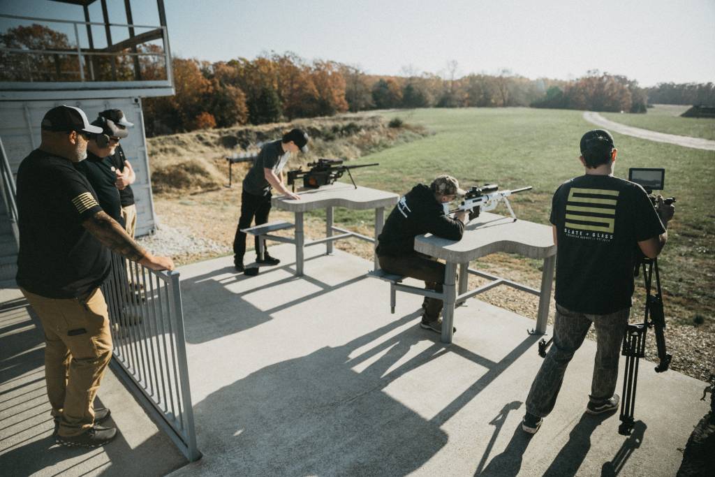 Two marksmen shooting long range with ai ballistic support.