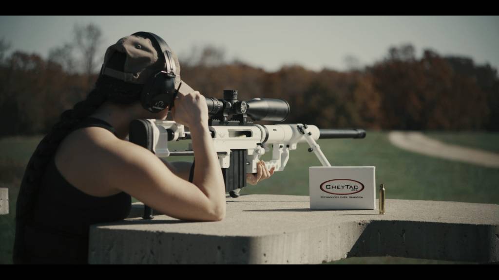 A woman with a sniper rifle and its bullets on a range