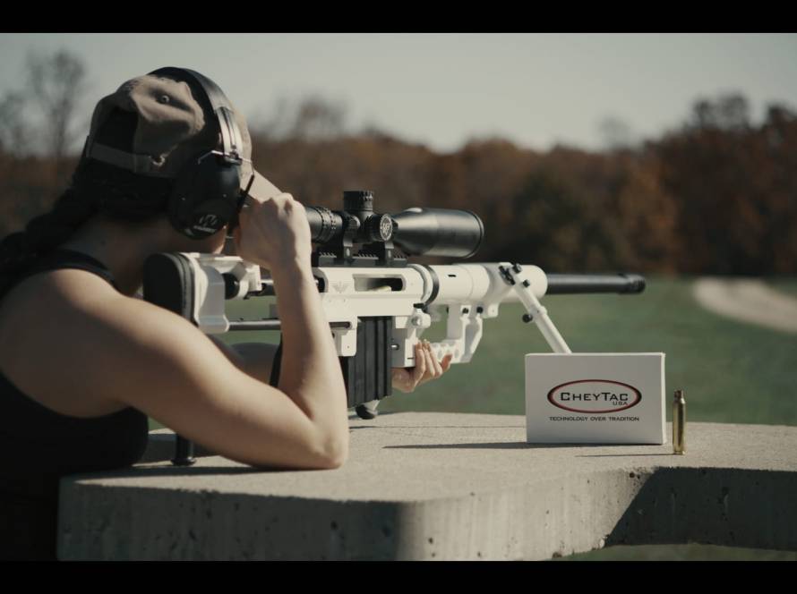 A woman with a sniper rifle and its bullets on a range