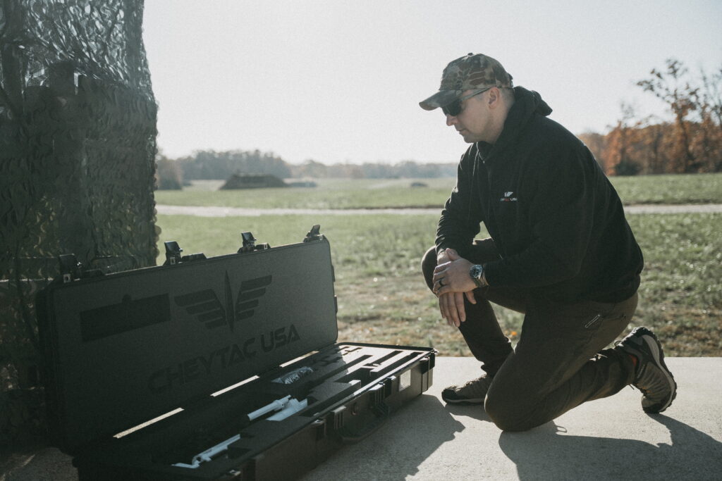 A man standing over his Pelican case that holds his M200 Intervention